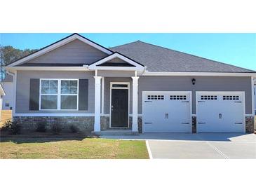 Charming single-Gathering home with a two-car garage, gray siding, and a well-manicured front lawn at 142 Oakchase Park Ln, Hampton, GA 30228