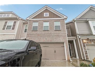 Attractive brick front exterior of a two-story home with a two-car garage at 7621 Avalon Blvd, Fairburn, GA 30213