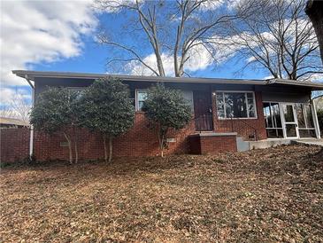 Brick ranch house with mature trees and a screened porch at 2069 Bixler Cir, Decatur, GA 30032