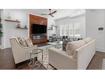 Bright living room featuring a sleek fireplace, a modern ceiling fan, and stylish decor at 165 Brush Creek Ct, Hampton, GA 30281