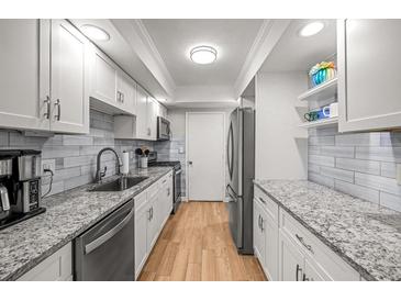 Well-lit kitchen with granite countertops, stainless steel appliances, and wooden floors at 6851 Roswell Rd # I18, Sandy Springs, GA 30328
