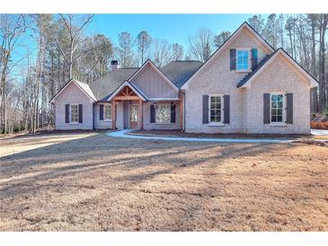 Brick home with a covered porch and landscaped yard at 211 Iroquois Ct, Covington, GA 30014