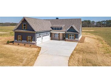 Charming craftsman home boasts a three-car garage and a beautifully landscaped front yard at 1452 Alcovy Station Rd, Covington, GA 30014