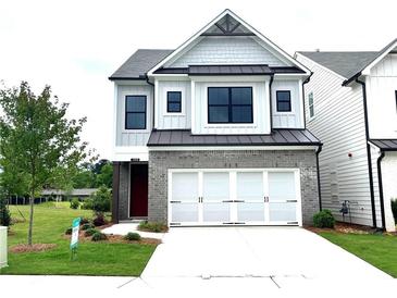Charming two-story home showcasing a brick and siding exterior, attached two car garage, and well manicured lawn at 1059 Crest Mill Dr, Marietta, GA 30008