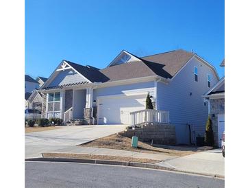 Two story home with gray siding, stone accents, and a two car garage at 413 Solace Pl, Canton, GA 30114