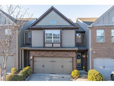 Two-story townhome with stone and siding exterior, two-car garage, and landscaping at 2354 Attewood Dr, Buford, GA 30519