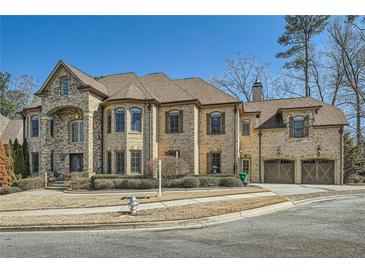 Impressive brick and stone home with arched entryway and well-maintained landscaping on a sunny day at 2015 Shaudi Ln, Atlanta, GA 30345