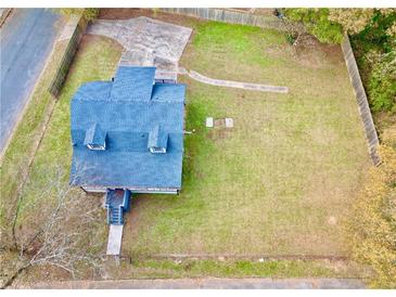 Overhead view of a home with a large lawn and driveway, surrounded by a wooden fence and mature trees at 2933 5Th Sw St, Atlanta, GA 30315