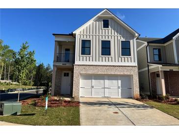 Charming two-story home featuring a two-car garage, stone accents, and vertical siding at 1074 Crest Mill Dr, Marietta, GA 30008