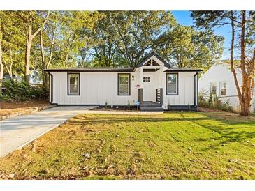 Newly renovated home with white exterior, landscaping, and a paved driveway at 358 Roy Sw St, Atlanta, GA 30310