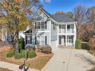 Two-story house with gray siding, a two-car garage, and a landscaped yard at 589 Lantern Wood Dr, Scottdale, GA 30079