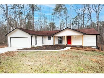 Charming single-story home with a bright red front door and attached two car garage at 6881 Hickory Hollow Dr, Douglasville, GA 30135