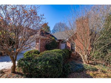 Charming brick home featuring a well-manicured front yard and mature trees at 341 Little John Nw Dr, Lilburn, GA 30047