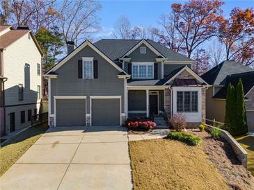 Traditional two-story home with gray siding, stone accents, a two-car garage, and landscaped front yard at 243 Yorkshire Ln, Villa Rica, GA 30180