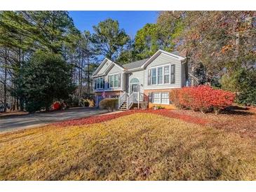 Charming two-story home with a well-manicured lawn and mature trees, showcasing inviting curb appeal at 242 Viola Dr, Dallas, GA 30157