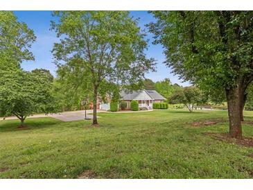 Expansive front yard with mature trees, basketball court, and charming single-Gathering home at 289 Barn Rd, Canton, GA 30115