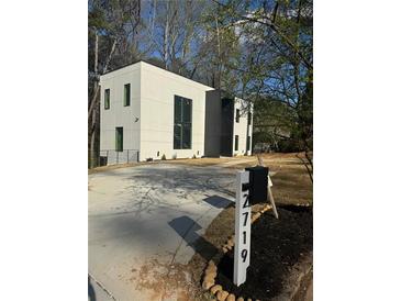 Modern two-story home featuring a concrete driveway and minimalist landscaping at 2719 Winding Ne Ln, Brookhaven, GA 30319