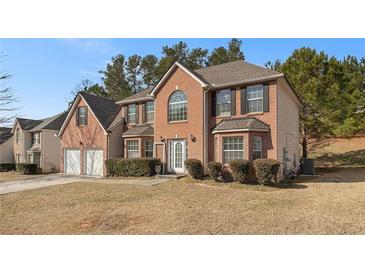 Charming two-story brick home with a manicured lawn and a two-car garage at 6849 Fireside Ln, Atlanta, GA 30349