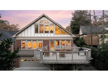 Stunning rear elevation with large deck, floor-to-ceiling windows, and garage access, perfect for entertaining at 833 E Morningside Ne Dr, Atlanta, GA 30324