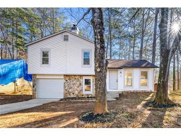 Charming home featuring stone accents, attached garage, and a cozy front porch at 708 Martin Rd, Stone Mountain, GA 30088