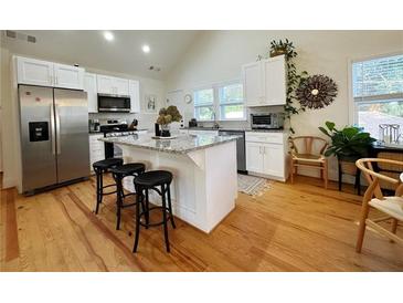 Bright kitchen with an island, granite countertops, modern appliances, and hardwood floors at 91 Morris Brown Sw Dr, Atlanta, GA 30314