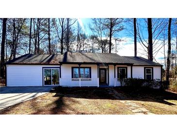 Newly renovated house exterior boasts white siding, dark trim, and a welcoming front porch at 204 Apple Branch Dr, Woodstock, GA 30188