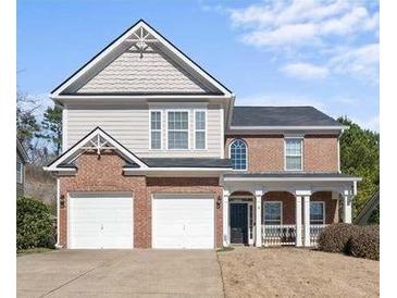 Charming two-story home featuring a brick facade, two-car garage, and covered porch area at 106 Puckett Ct, Canton, GA 30115