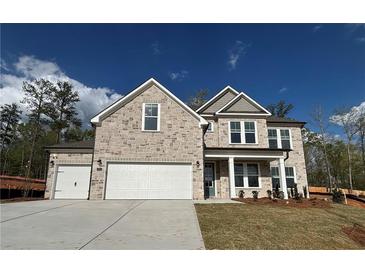 Charming stone two-story home featuring a three-car garage and landscaped front yard at 6969 Melody Dr, Buford, GA 30518