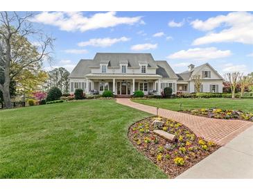 Expansive two-story home features a brick path with lush landscaping and a manicured lawn at 710 Cox Rd, Roswell, GA 30075