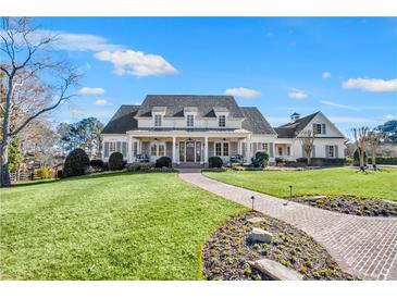 Stunning home with a well-manicured lawn, brick walkway and charming front porch at 710 Cox Rd, Roswell, GA 30075