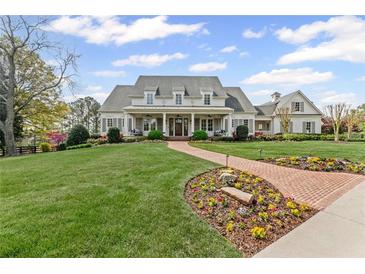 Stunning two-story home with a manicured lawn and a charming brick walkway leading to the entrance at 710 Cox Rd, Roswell, GA 30075