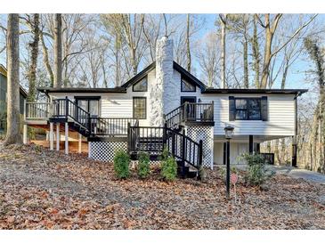 Charming white house with black accents, deck, and stone chimney at 1695 Bull Sw Run, Lilburn, GA 30047