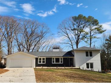 Stunning renovated ranch home with a two-car garage, showcasing a modern black and white exterior at 1536 Daffodil Dr, Marietta, GA 30062