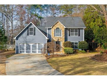 Gray two-story house with stone accents, three-car garage, and landscaped yard at 2410 Emerald Dr, Loganville, GA 30052