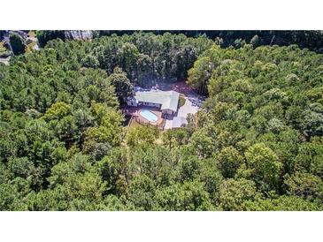 Stunning aerial view of a home nestled among lush greenery with a sparkling backyard pool at 2784 Sixes Rd, Canton, GA 30114