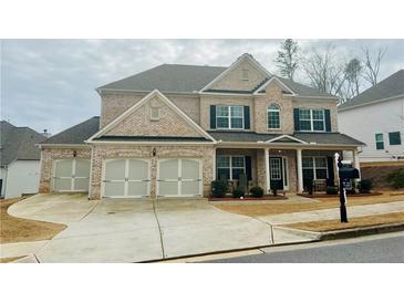 Traditional two-story brick home featuring a three-car garage and covered front porch at 96 Wentworth Cir, Villa Rica, GA 30180