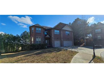 Brick two-story house with three-car garage and landscaped lawn at 870 Belmar Pass, Fairburn, GA 30213