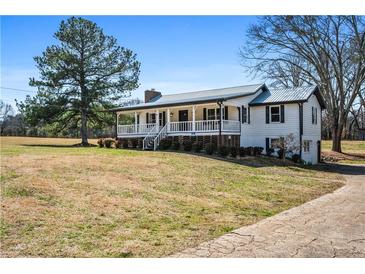 Charming two-story farmhouse with a metal roof, white siding, and a welcoming front porch at 5333 Pine Valley Rd, Powder Springs, GA 30127