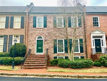 Brick townhouse with green door, shutters, and landscaping at 207 Townsend Pl, Atlanta, GA 30327