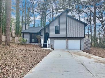 Charming two-story house with a gray exterior, two-car garage, and a long driveway at 3814 Whaley Ct, Snellville, GA 30039