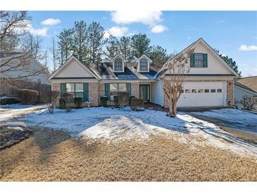 Charming one-story house with a white and brick exterior, two-car garage, and snow-covered lawn at 1112 Autumn Glen Way, Dacula, GA 30019