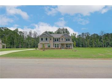Beautiful two-story home with a large front yard and brick and gray siding at 157 Haverling Pass, Hampton, GA 30228