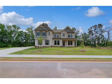 Beautiful two-story home featuring a manicured lawn and light-colored brick facade at 157 Haverling Pass, Hampton, GA 30228