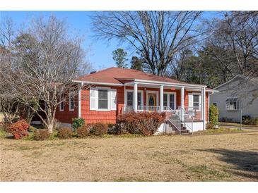 Charming single-story home featuring a welcoming front porch, red siding, and white trim at 318 Stewart Nw Ave, Marietta, GA 30064