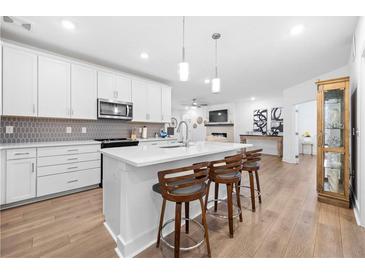 Modern kitchen featuring a spacious island with quartz countertop and pendant lighting at 3211 Orwell Way # 4302, Cumming, GA 30041