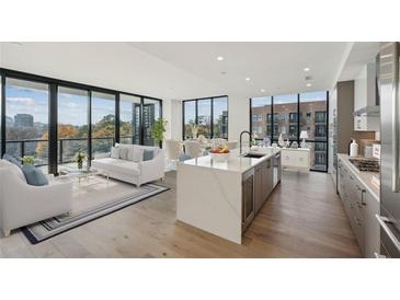 Bright and airy living room with floor-to-ceiling windows and modern kitchen with island at 2425 Peachtree Ne Rd # 510, Atlanta, GA 30305