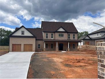 Stately brick home featuring a covered porch and two-car garage at 1949 Pucketts Sw Dr, Lilburn, GA 30047