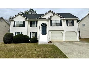 Charming two-story home with a well-manicured lawn, attached garage, and inviting blue front door at 2961 Rolling Ln, Winston, GA 30187