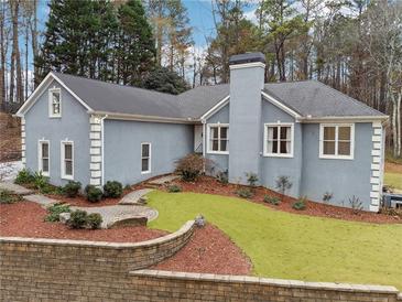 Gray house with landscaped yard, stone wall, and walkway at 38 Timberlost Trl, Suwanee, GA 30024