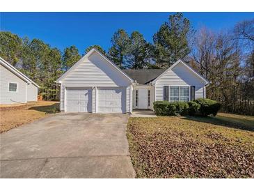 White house with two-car garage and well-maintained lawn at 6959 Biscayne Blvd, Rex, GA 30273